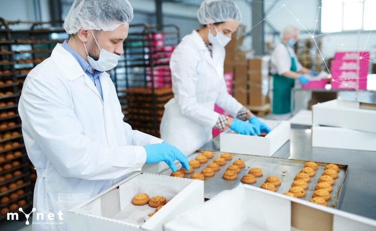 la sicurezza aziendale ai tempi del Coronavirus: persone che lavorano distanziate e con la mascherina