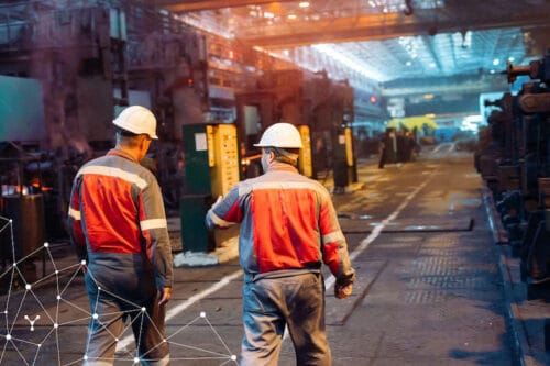 il settore industria: due uomini in tuta da lavoro che usano il software risorse umane MyNet