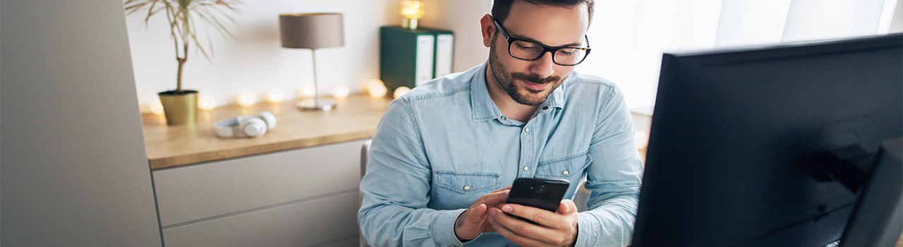 significato smart working: uomo che lavora in modalità agile e adopera l'app aziendale