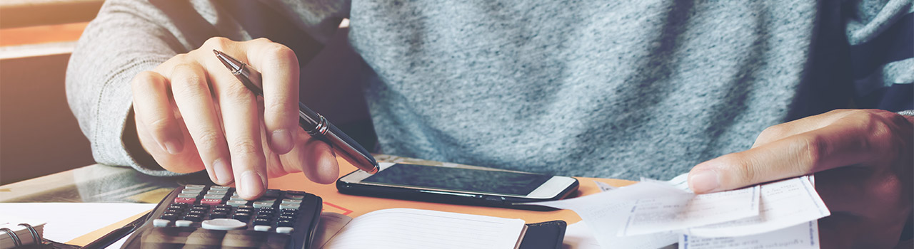 nota spese aziendale: persona con calcolatrice e scontrini