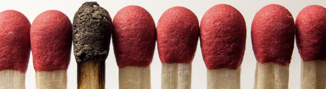 cause del burnout: un fiammifero è bruciato in mezzo ad altri integri