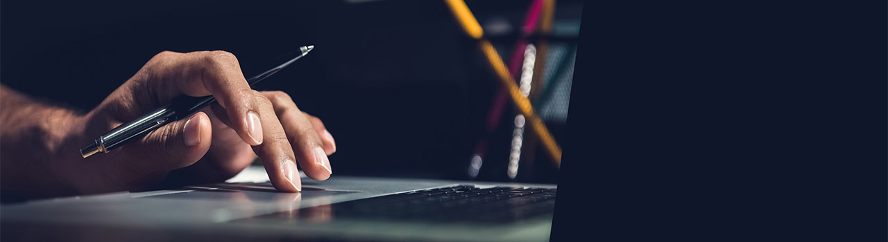 mano impugna una penna mentre scrive al computer, studio per ore