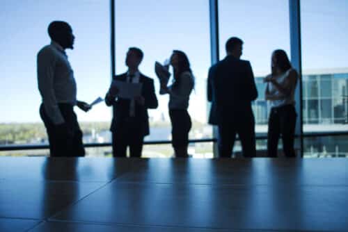 employer branding: profili di persone che chiacchierano in ufficio davanti a una vetrata