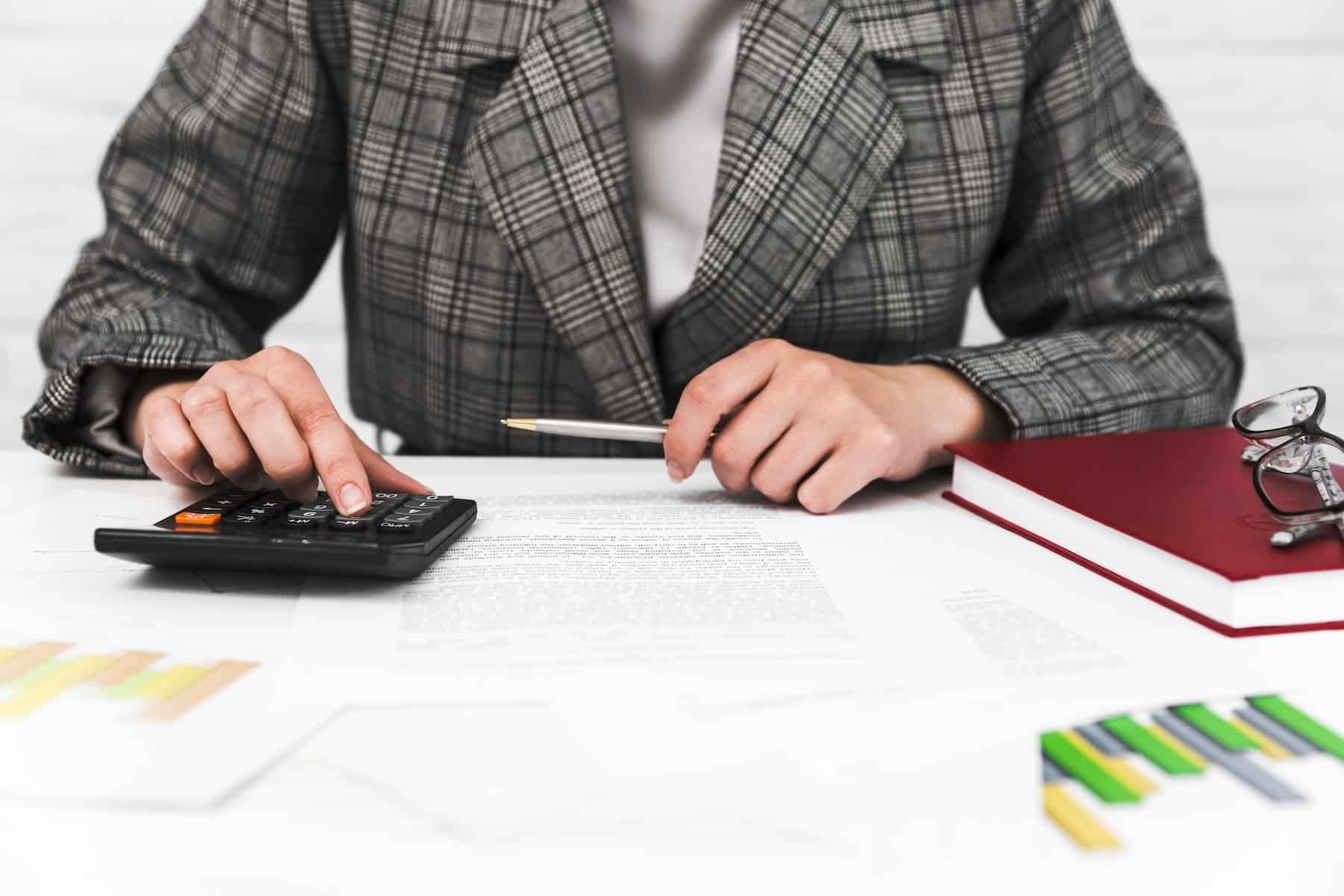 tassazione straordinari in busta paga: persona che fa calcoli con la calcolatrice